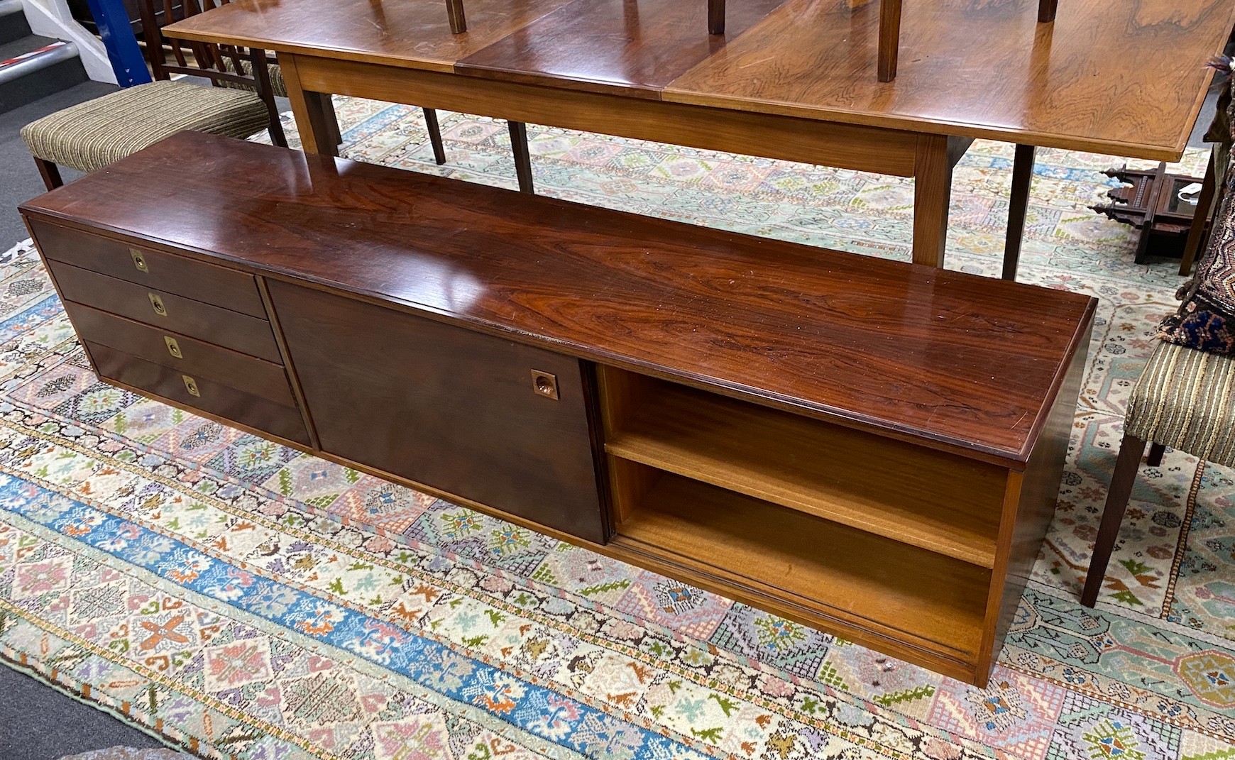 A mid century rosewood extending dining table, length 214cm extended, width 84cm, height 72cm six chairs and wall hanging side cabinet